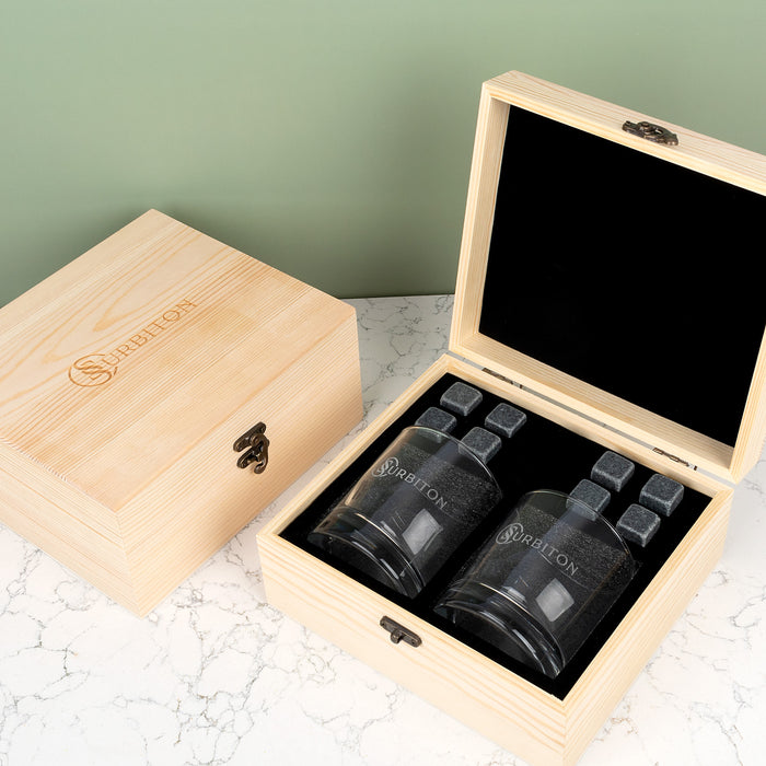 Premium corporate whiskey gift set in a wooden box with engraved round glasses, whiskey stones and space for company branding.