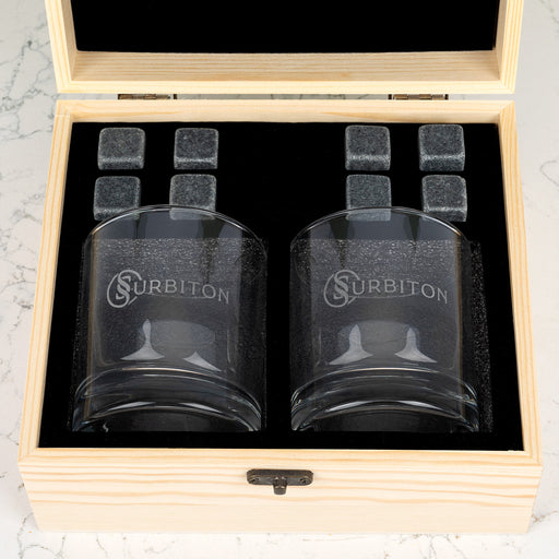Wooden whiskey gift box open to reveal personalised glasses and reusable whiskey stones for corporate gifting.