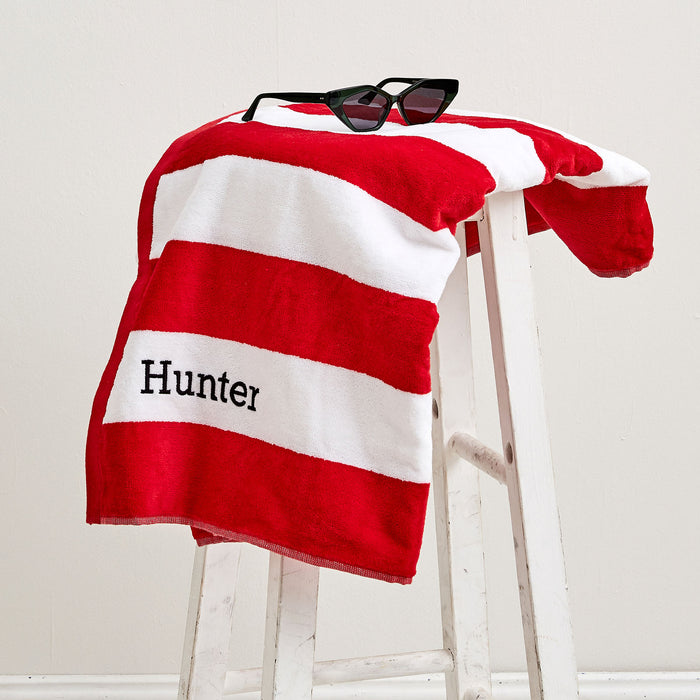 Red striped kids’ towel with personalised black embroidery – ideal for summer fun