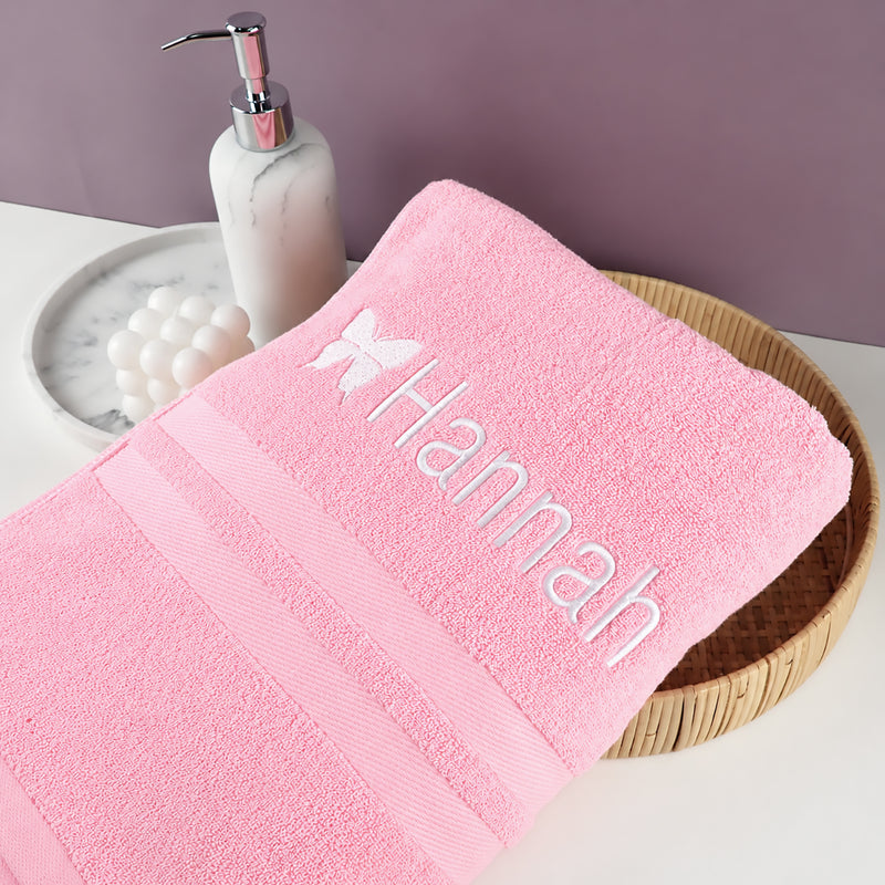 Soft cotton personalised children's bath towel in pink featuring embroidered butterfly and custom name, perfect for bath time.