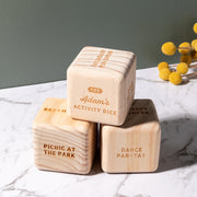 Natural wood dice engraved with family name and weekend activity ideas like picnic or beach