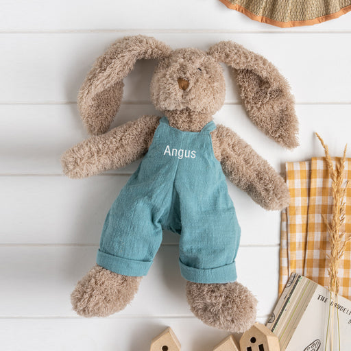 Personalised taupe bunny rabbit wearing dusty blue embroidered overalls with a child’s name, a perfect gift for Easter, birthdays, or newborns.