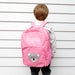 Child wearing a custom koala backpack, showcasing name embroidery and front design.