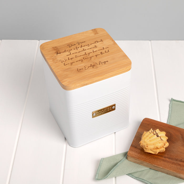 Personalised white cookie tin with engraved bamboo lid and gold COOKIE badge, styled on a kitchen countertop.