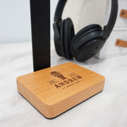 Personalised headphone stand displaying one pair of headphones on a desk with a smooth beech wood finish.