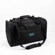 Black personalised duffle bag with teal embroidered initials on front pocket