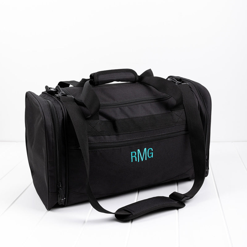 Black personalised duffle bag with teal embroidered initials on front pocket