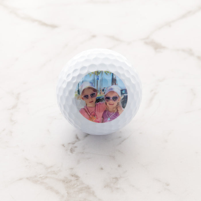 Set of three personalised golf balls with custom photo, presented in a black gift box.