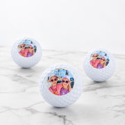 Set of three personalised golf balls with custom photo, presented in a black gift box.
