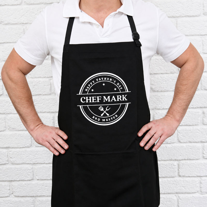Personalised black BBQ apron with bold white print and custom name, a practical gift for Dad, Grandad or the BBQ King.