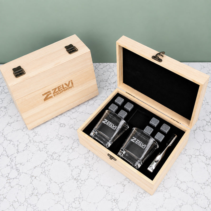 Branded whiskey gift set with square whiskey glasses, reusable stones, stainless steel tongs and personalised wooden box for corporate gifting.