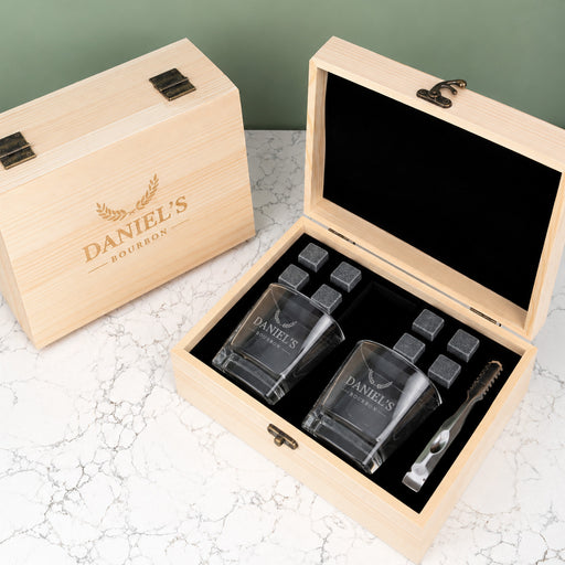Personalised whiskey gift set with two engraved square glasses, eight reusable whiskey stones and a black velvet storage bag in a wooden gift box.